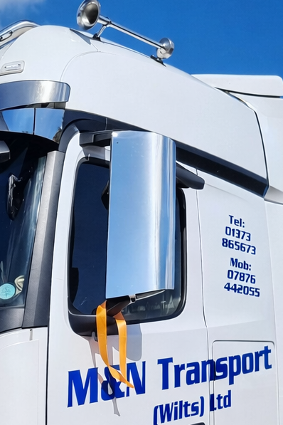 Blue and white truck with 'M&N Transport' branding on a clear day.