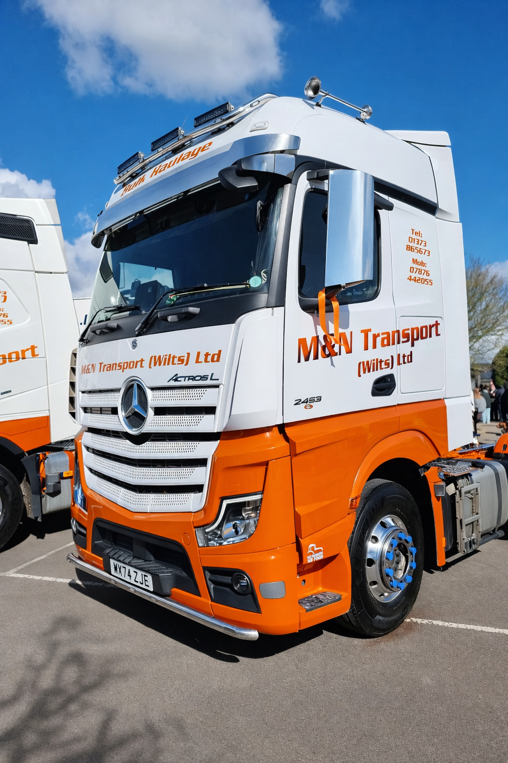 Orange and white truck with 'M&N Transport' branding on a clear day.